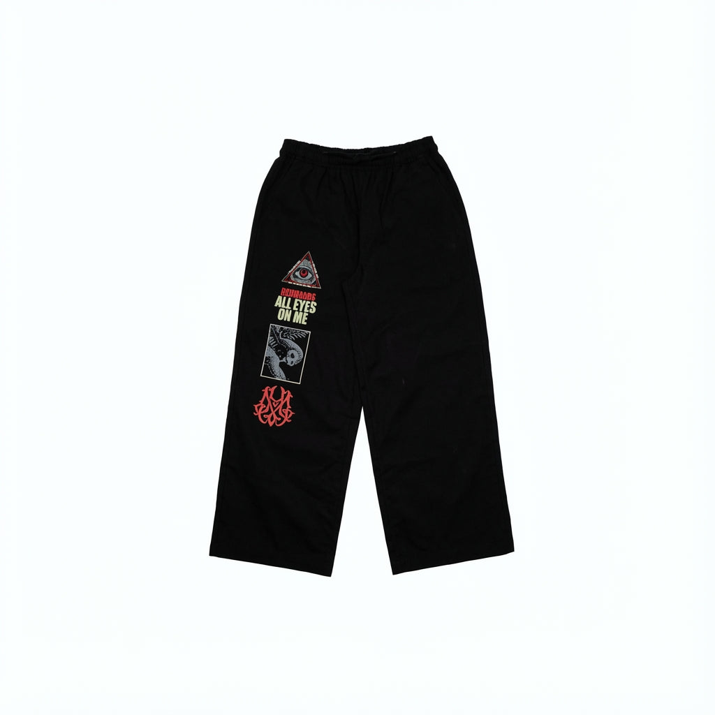 Black twill pants with eye, owl, and text graphics.